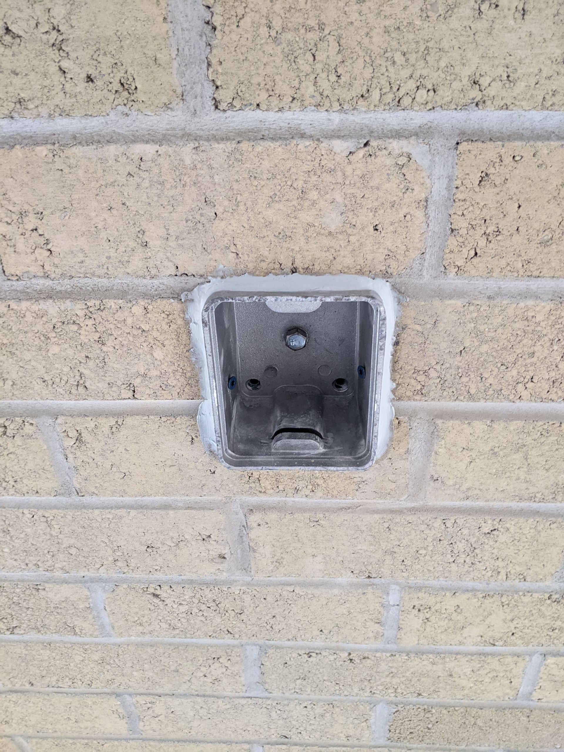 A brick wall with a square hole in it