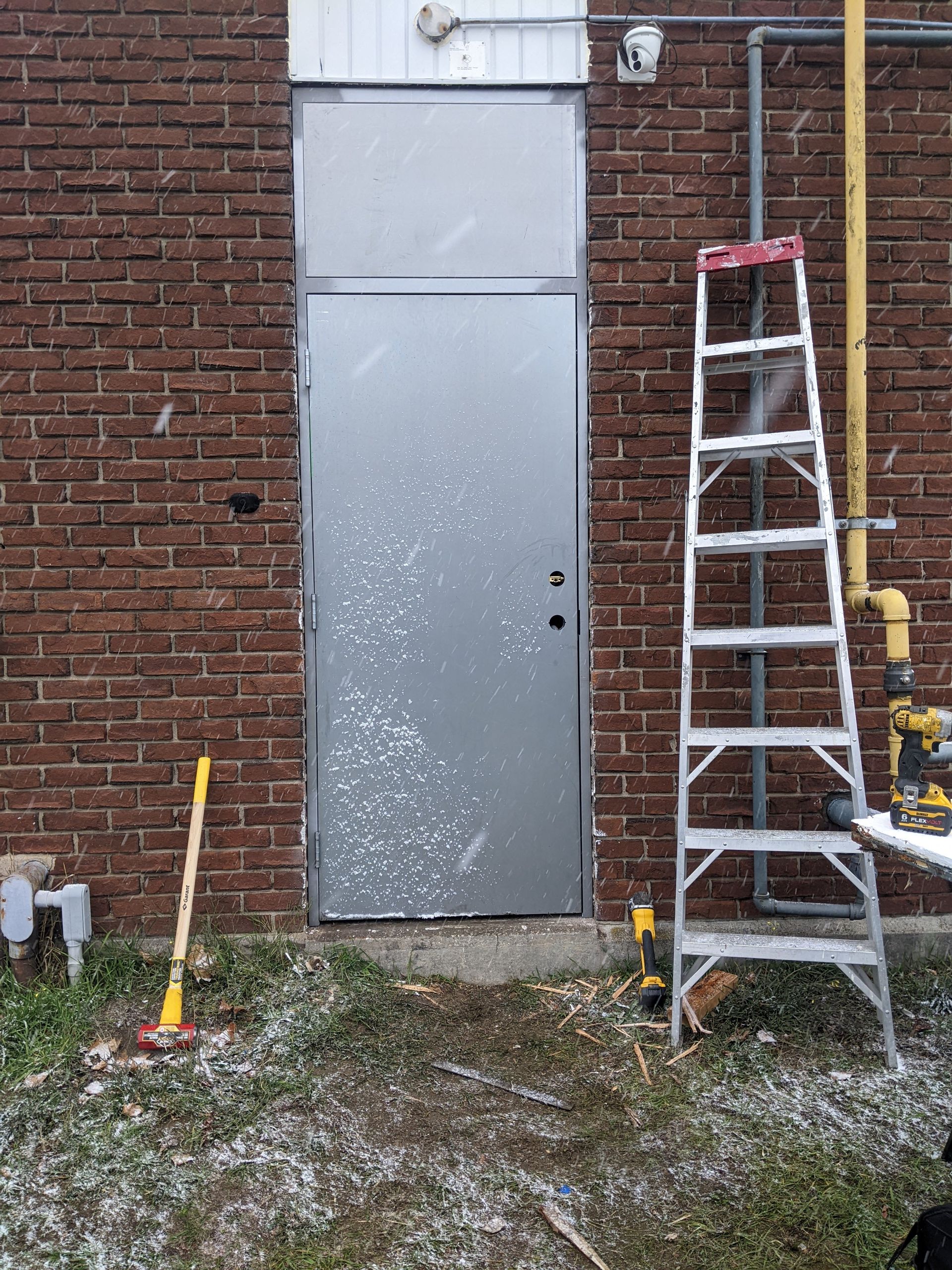 A ladder is leaning against a brick wall next to a door
