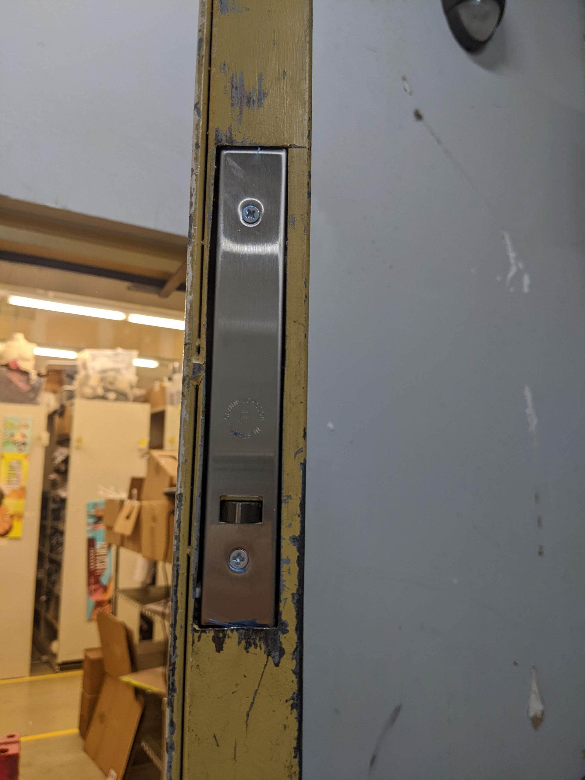 A close up of a door with a stainless steel latch