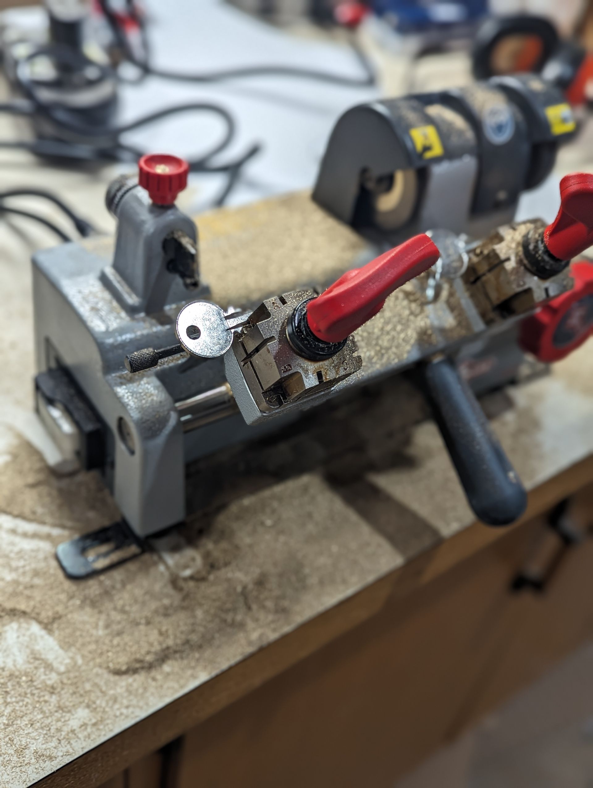A key cutting machine is sitting on a wooden table.