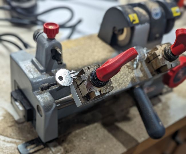 A close up of a key cutting machine on a table.