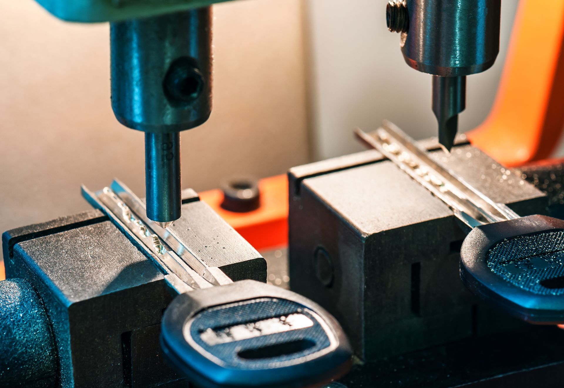 Key cutting machine duplicating two car keys.