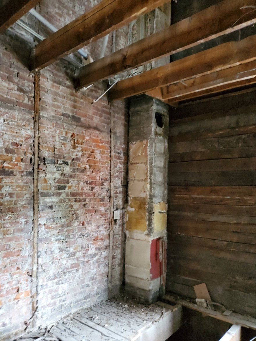 Une pièce avec un mur de briques et une cheminée.