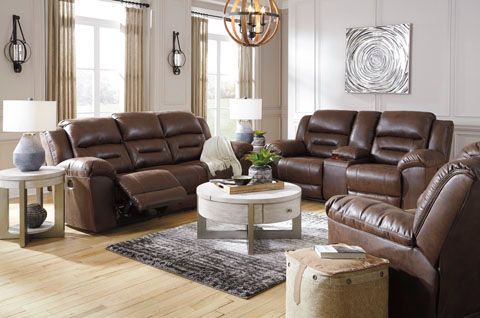 Living room with gray sofas, a dark wood coffee table, and cream-colored walls. Brown and beige patterned rug on the floor.
