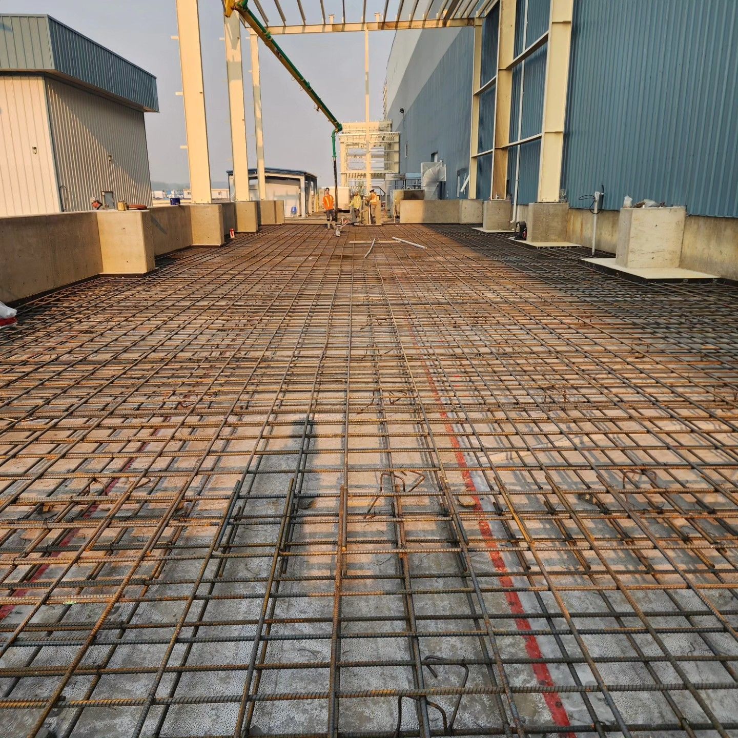 Steel rebar grid on a rooftop deck between industrial buildings under construction