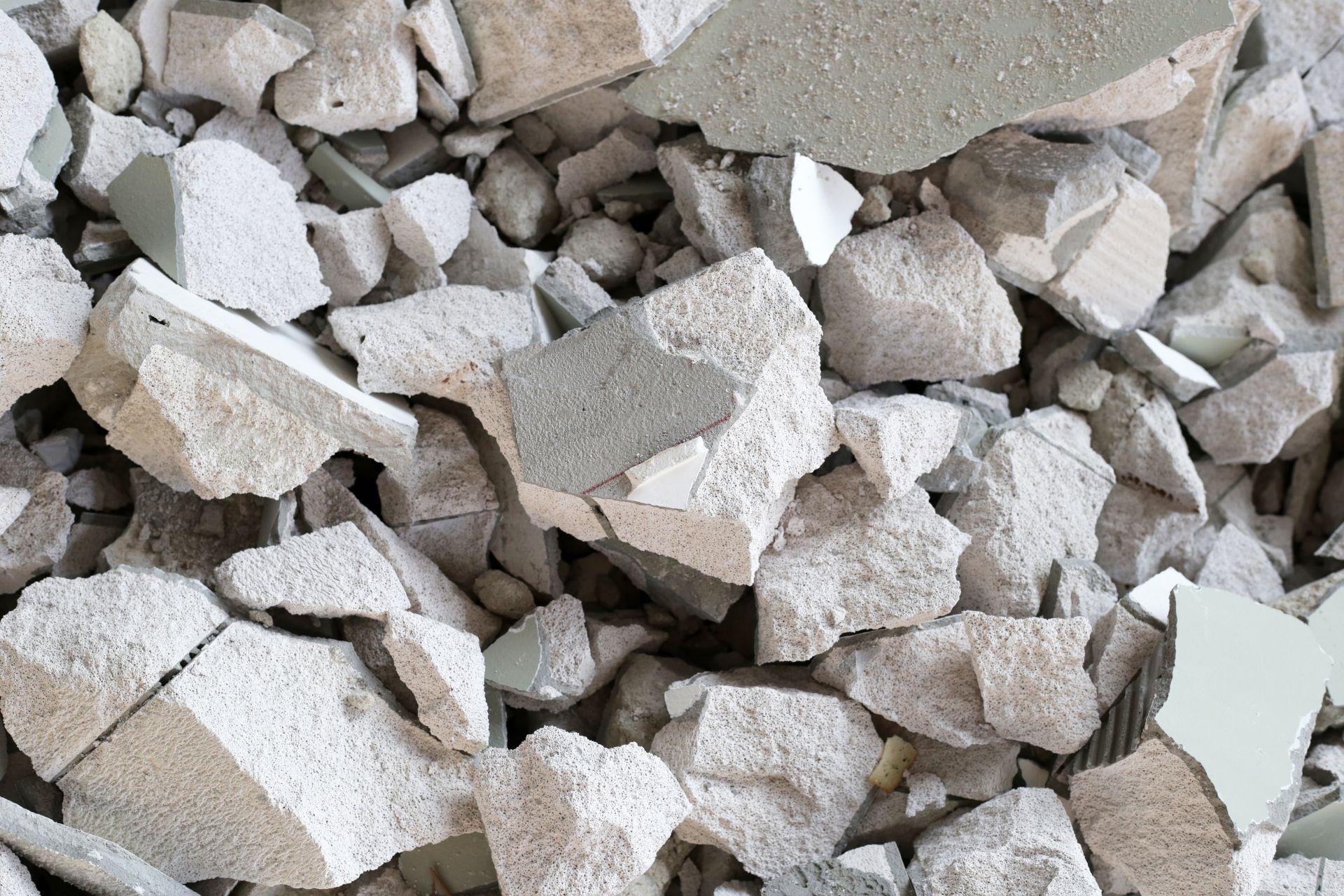 Pile of broken white and beige stone or concrete rubble on the ground