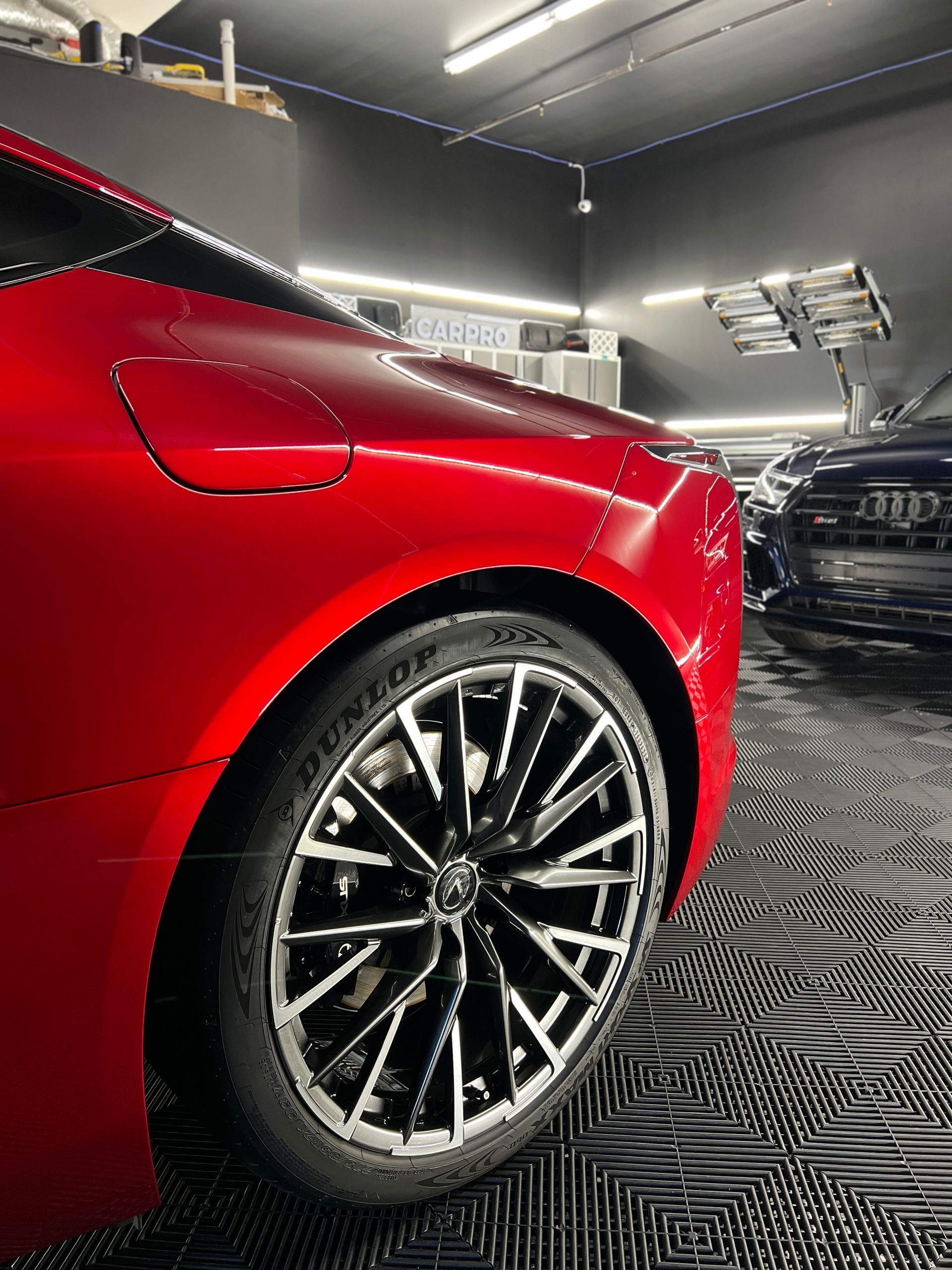 A red sports car is parked in a garage.
