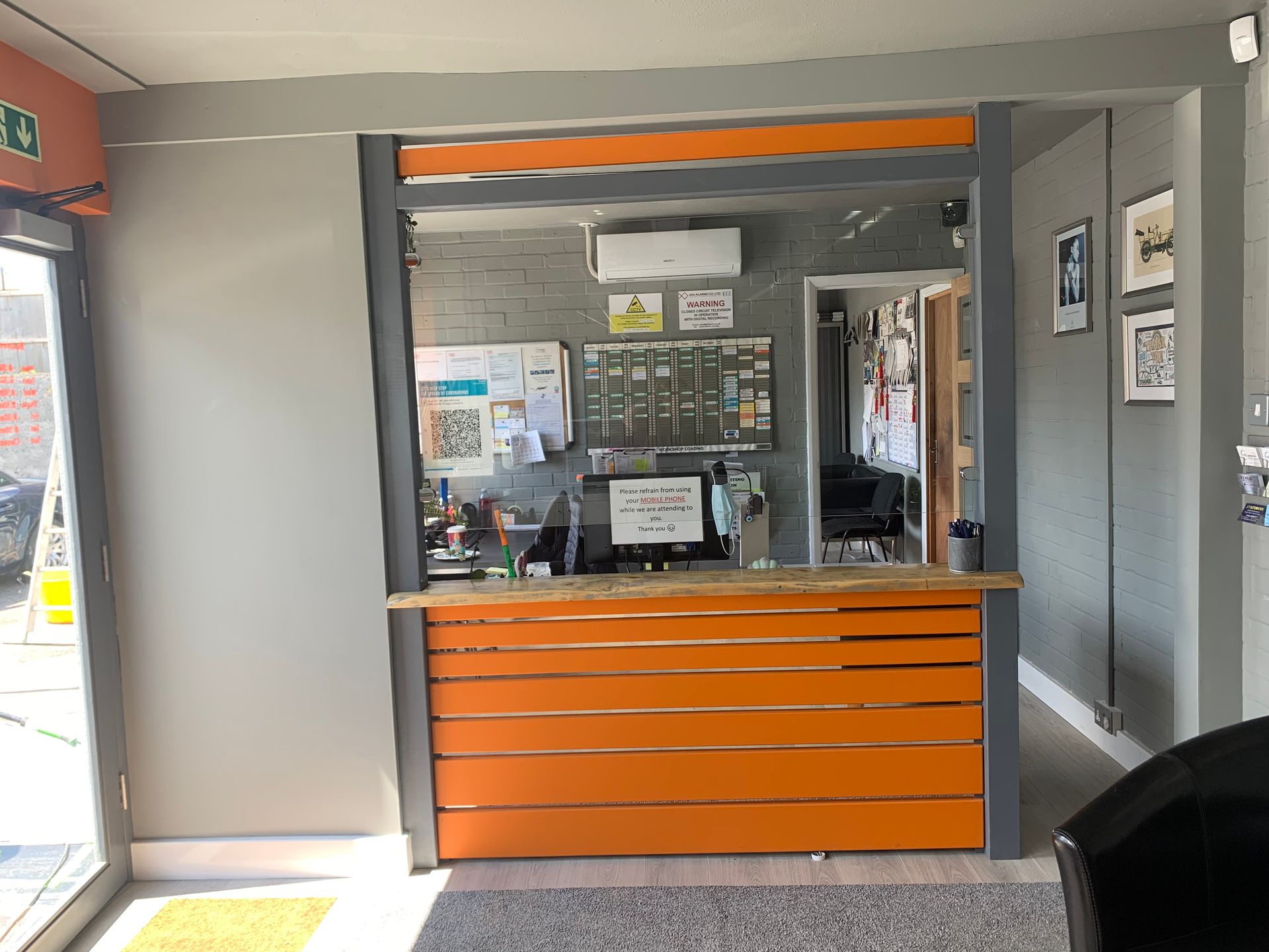 TEC Automotive reception area with a wooden counter and a computer on it.