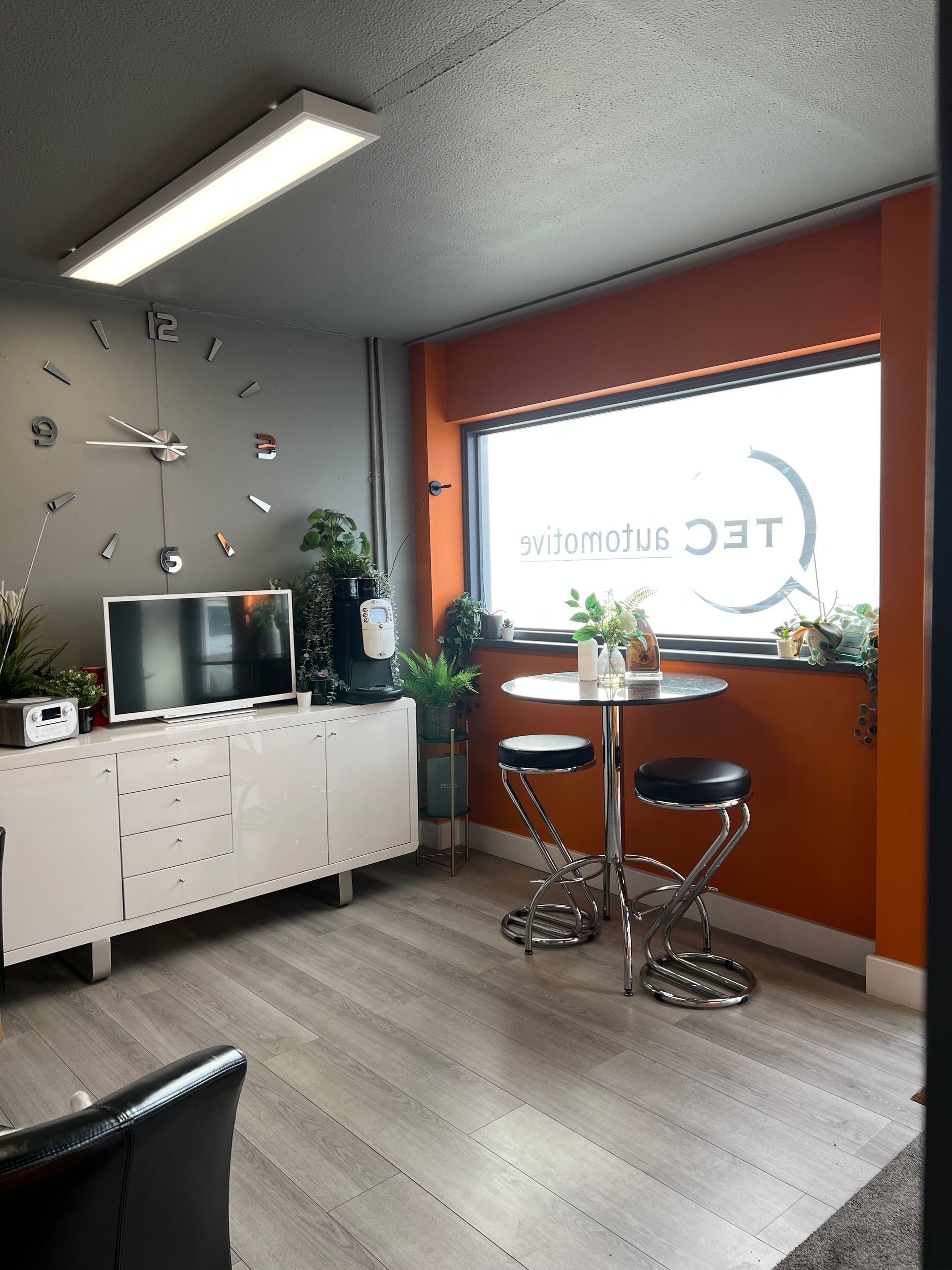 A living room with a table and a clock on the wall