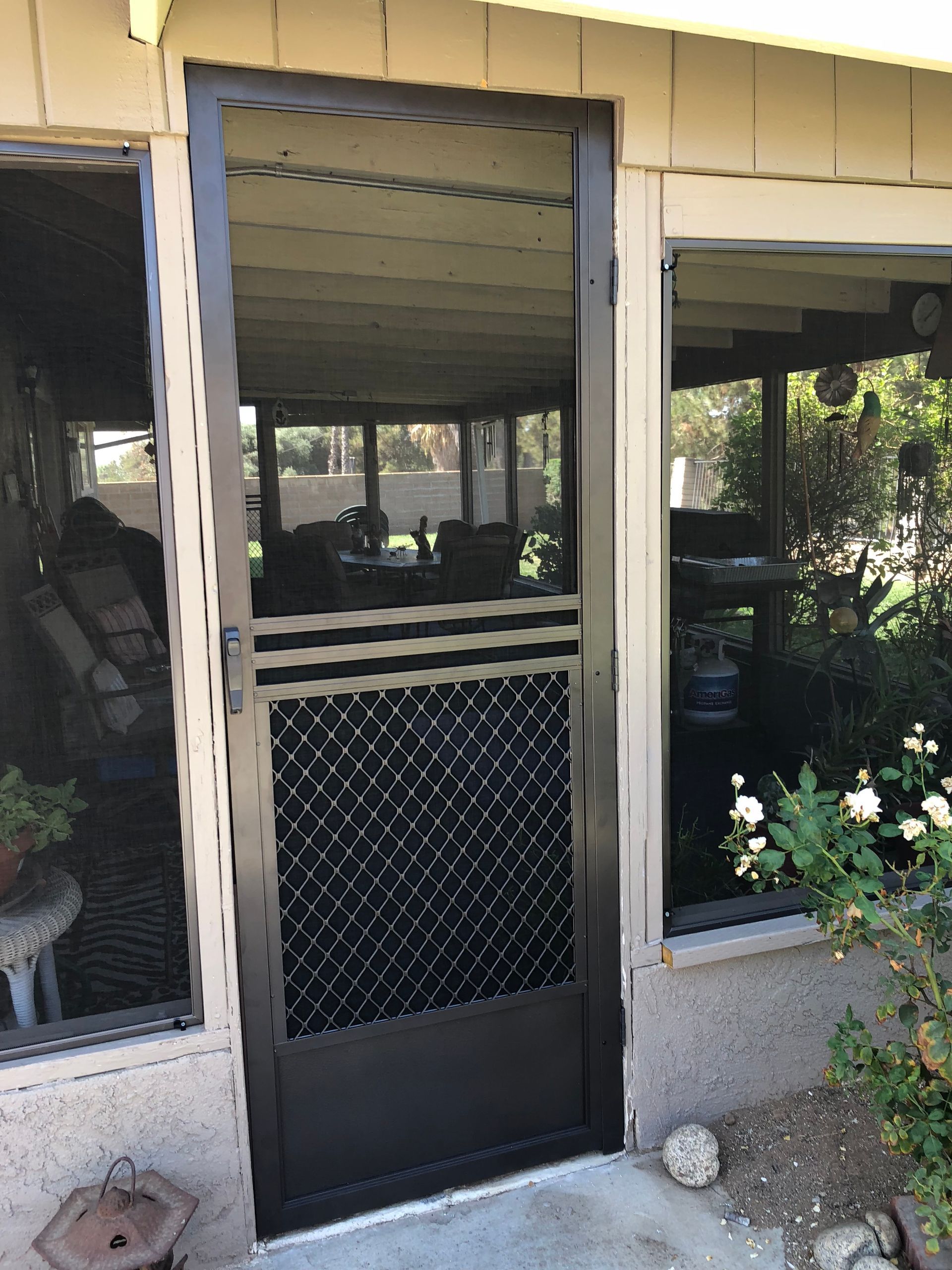 Front entry with a black screen door featuring a lower mesh panel