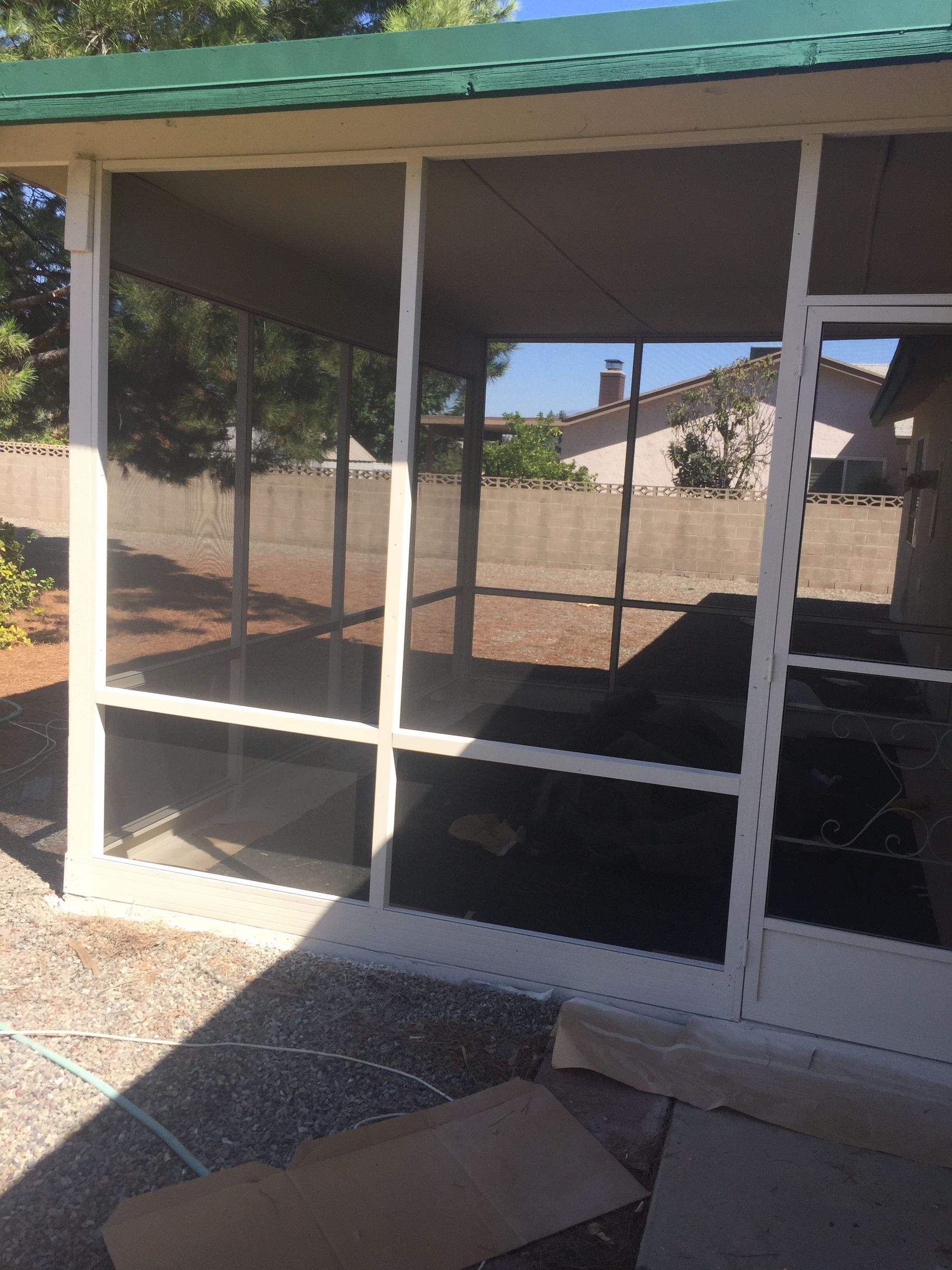 Screened patio enclosure with white framing and mesh panels