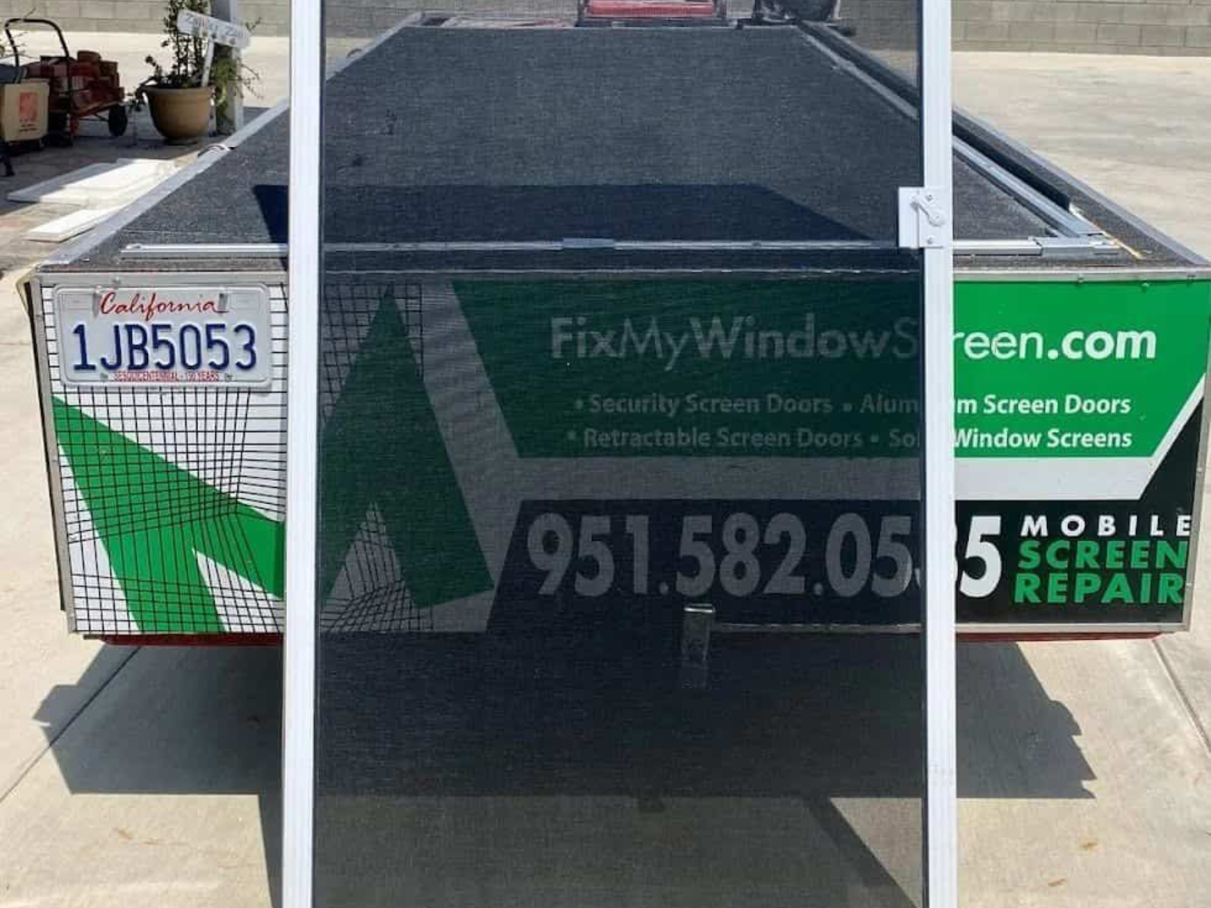 Sliding screened door with a solar mesh showing a service vehicle behind.
