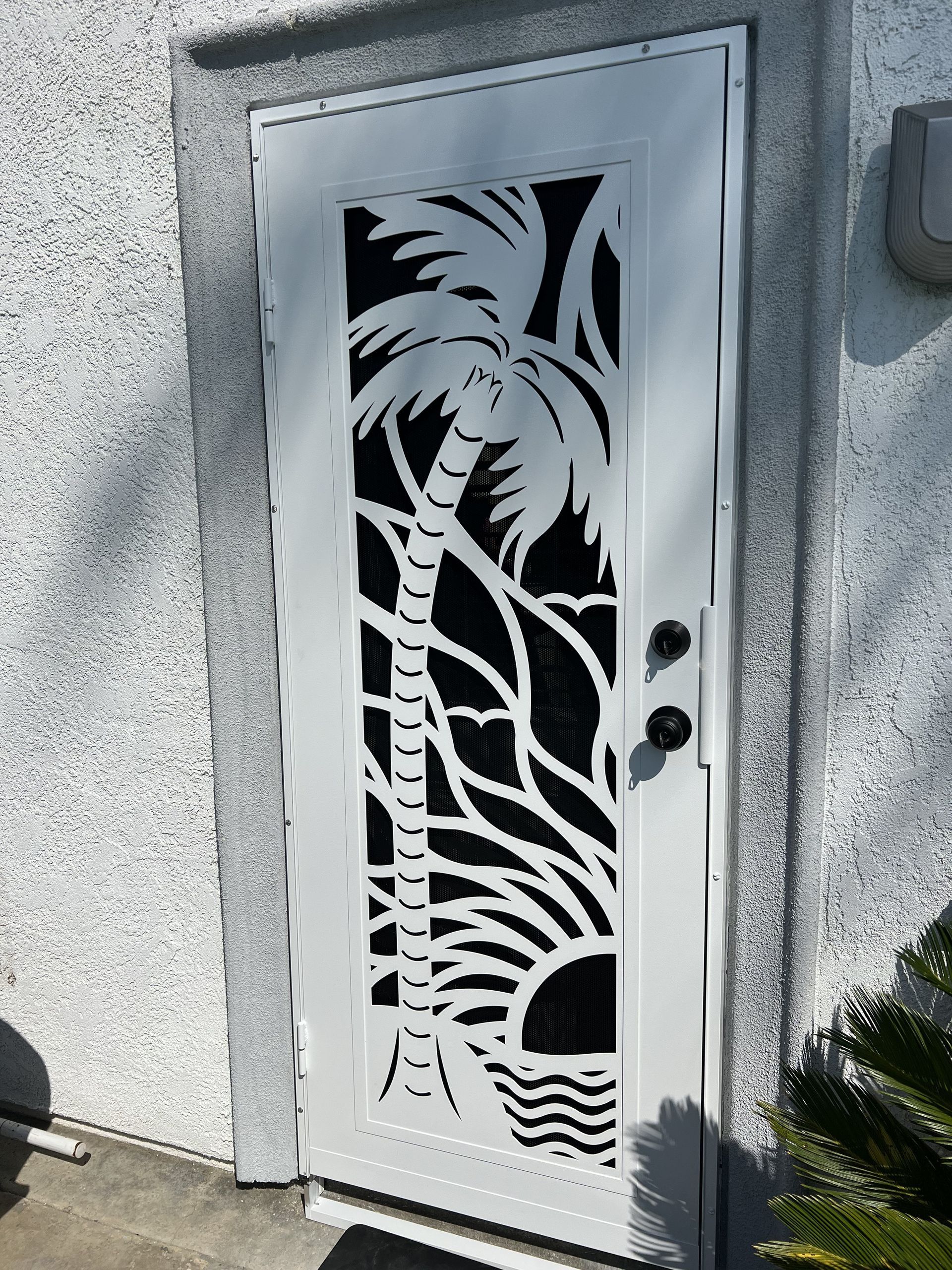 White security screen door with tropical leaf cutout design