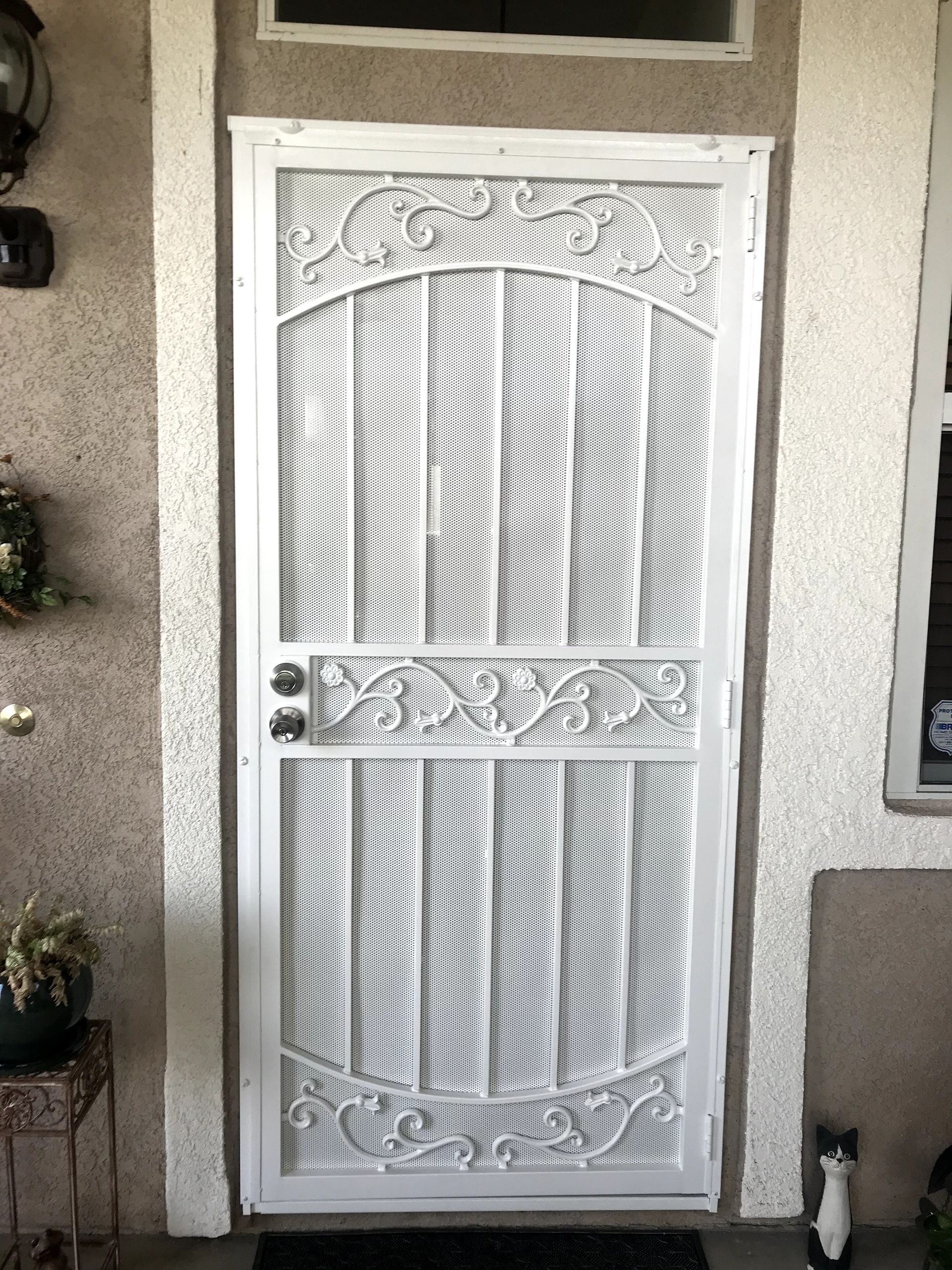 White security screen door with decorative curved metal design