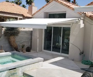 Motorized retractable awning installed over a residential pool