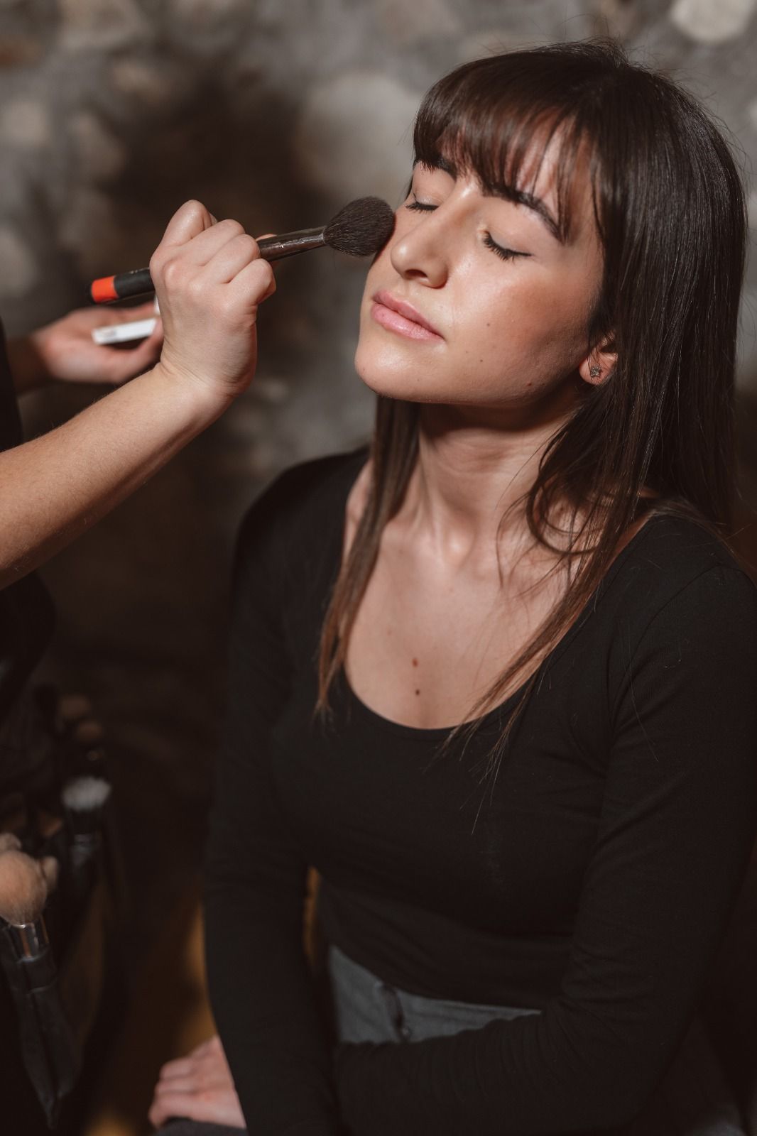 Una donna si sta facendo truccare da un truccatore.