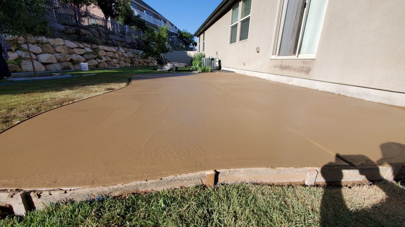 A concrete patio is being built in front of a house.