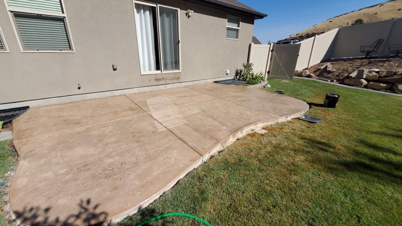 A concrete walkway is sitting in the grass in front of a house.