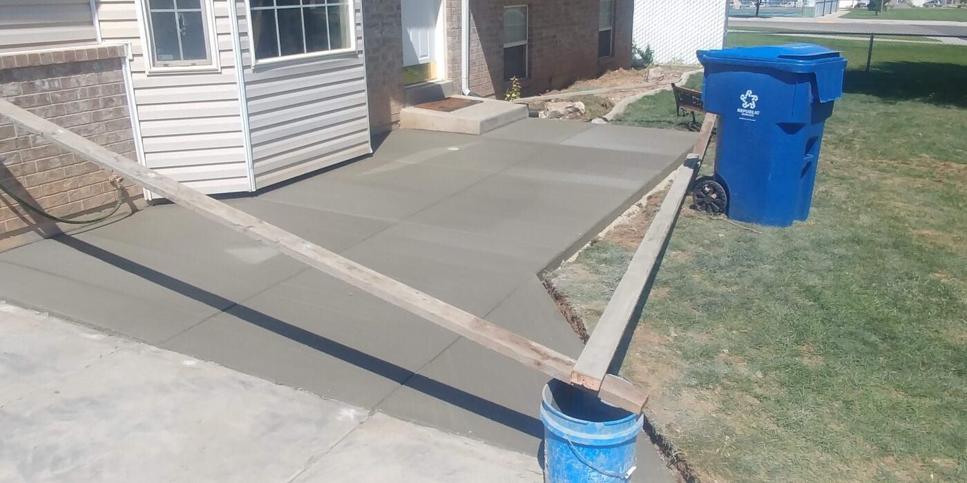 A concrete walkway is being built in front of a house.