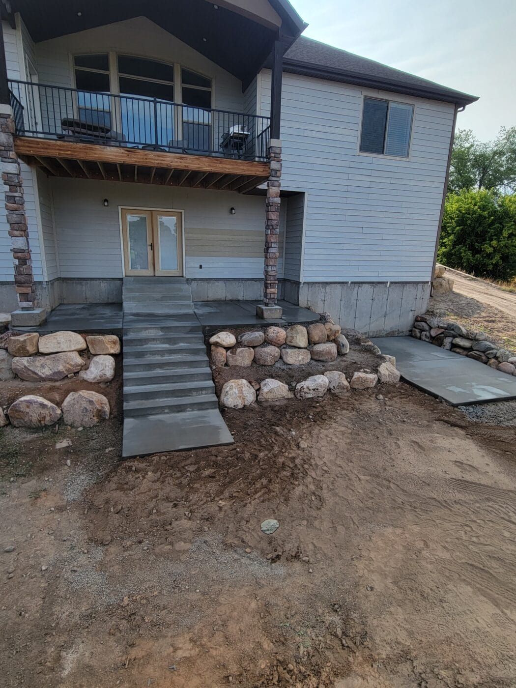 A house with a deck and stairs in front of it.