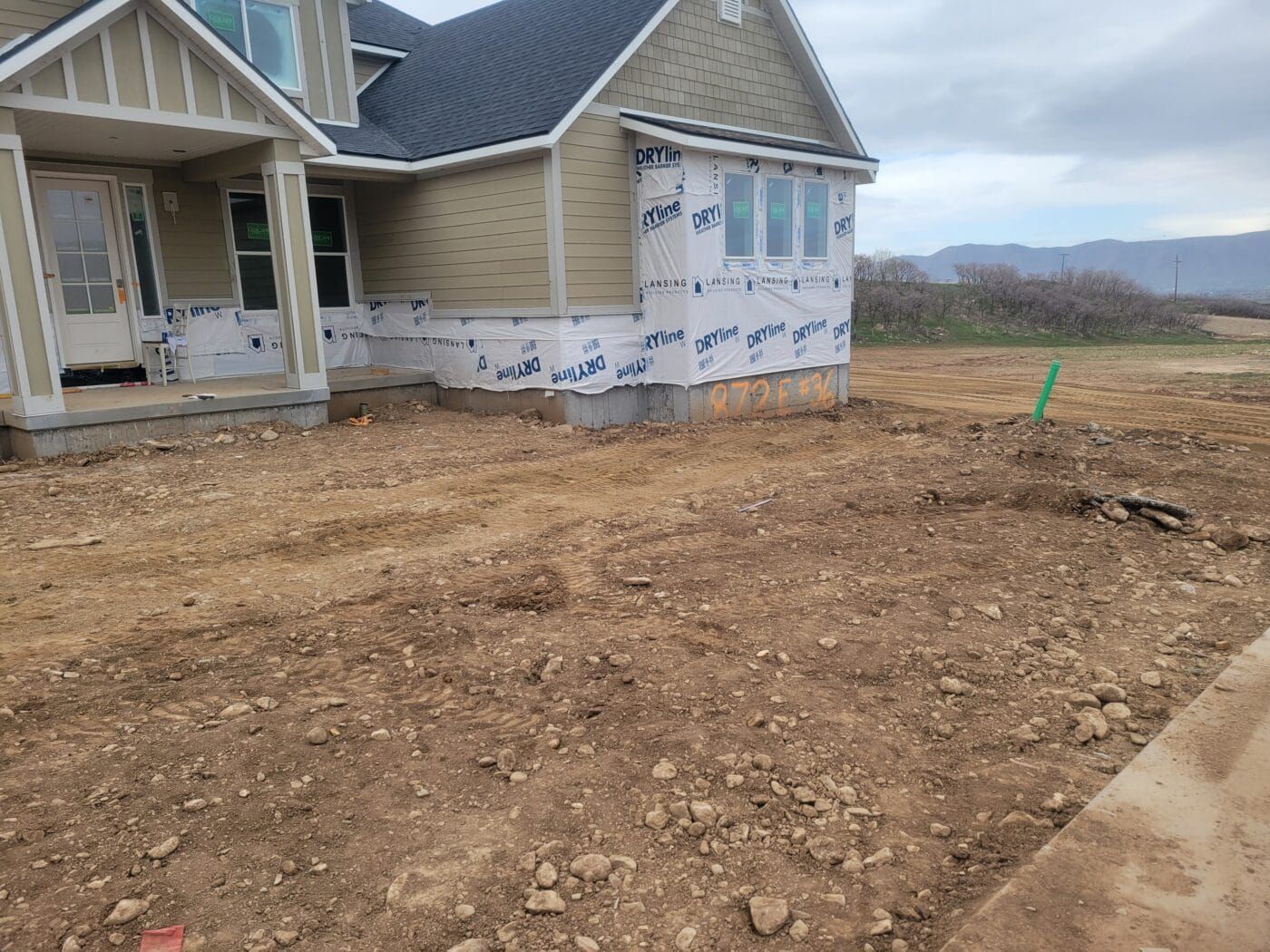 A house is being built in a dirt field.
