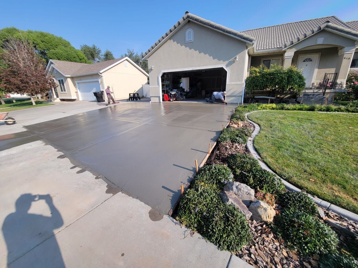 A concrete driveway is being built in front of a house.