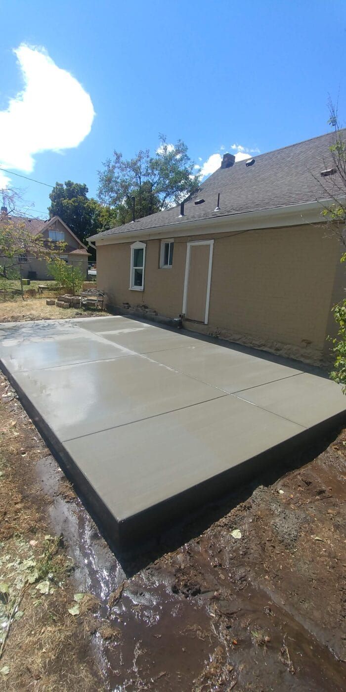 A concrete driveway is being built in front of a house.