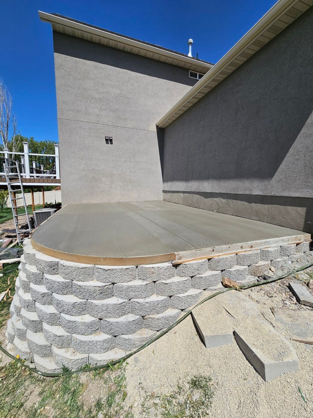 A concrete deck is being built in front of a house.