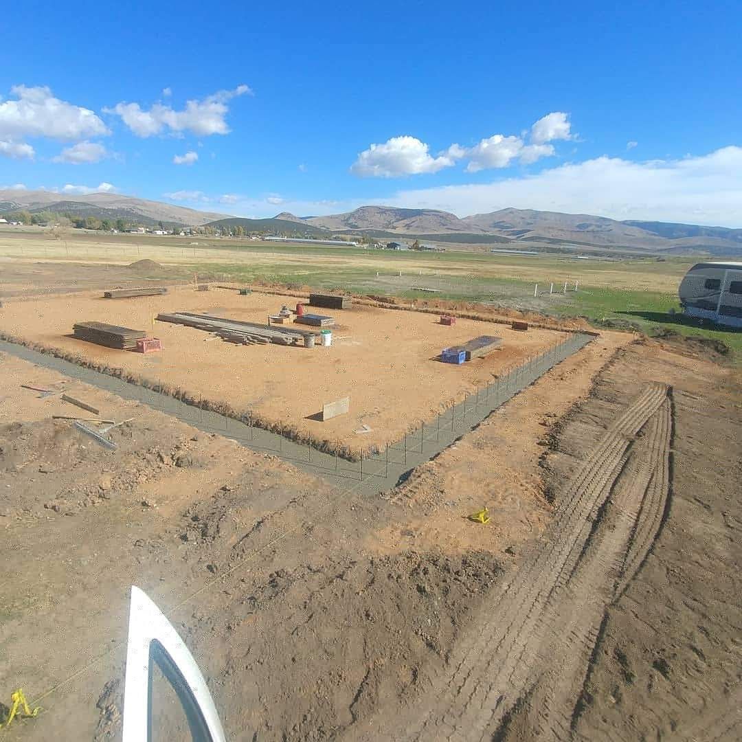 An aerial view of a dirt field with mountains in the background.