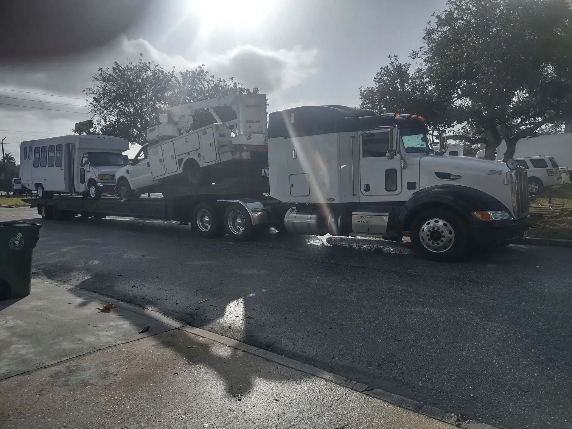 a white truck is towing a rv down a street