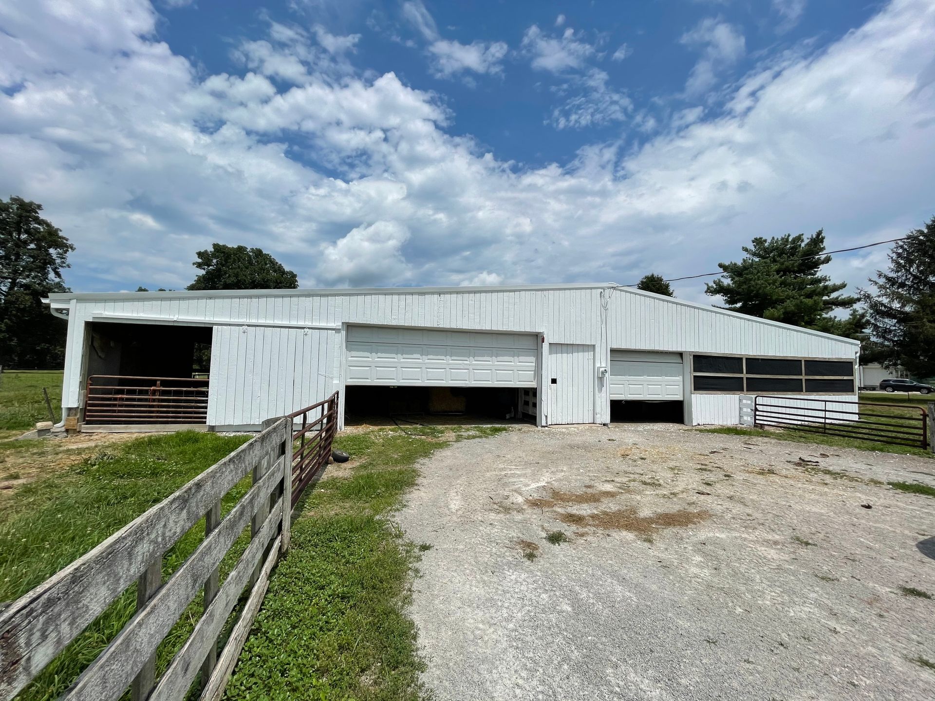 A large white building with a wooden fence in front of it.