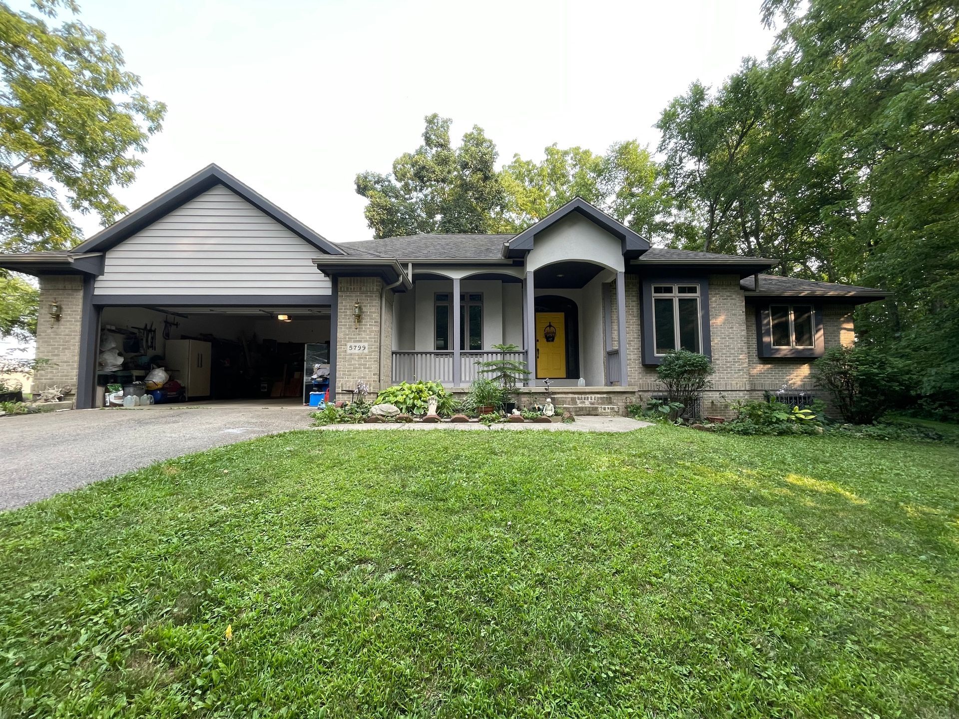 A house with a large lawn in front of it and a garage.