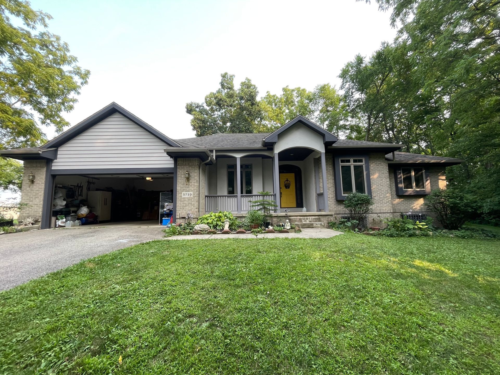 A large house with a garage and a large lawn in front of it.