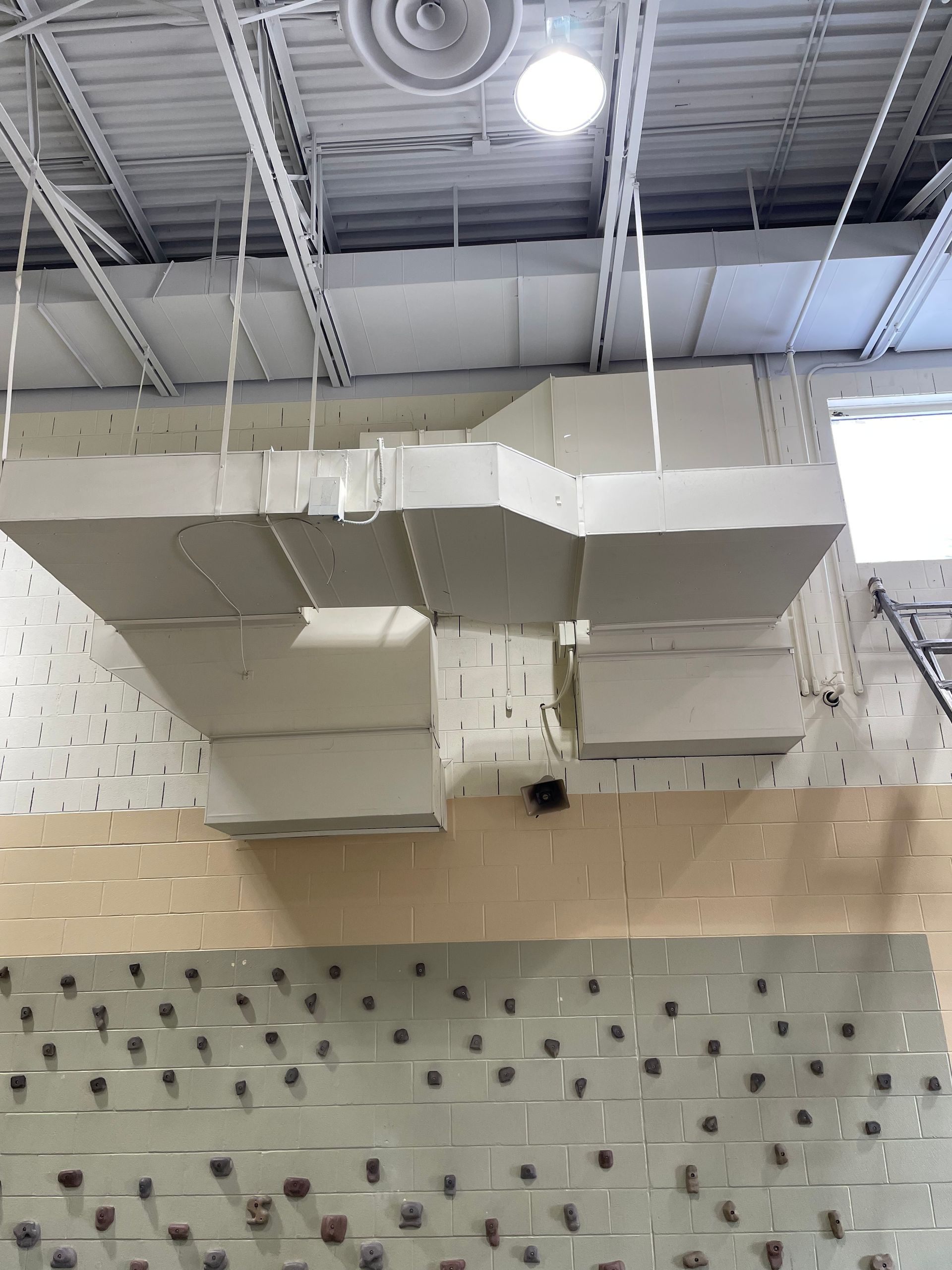 A ceiling with a lot of ducts hanging from it