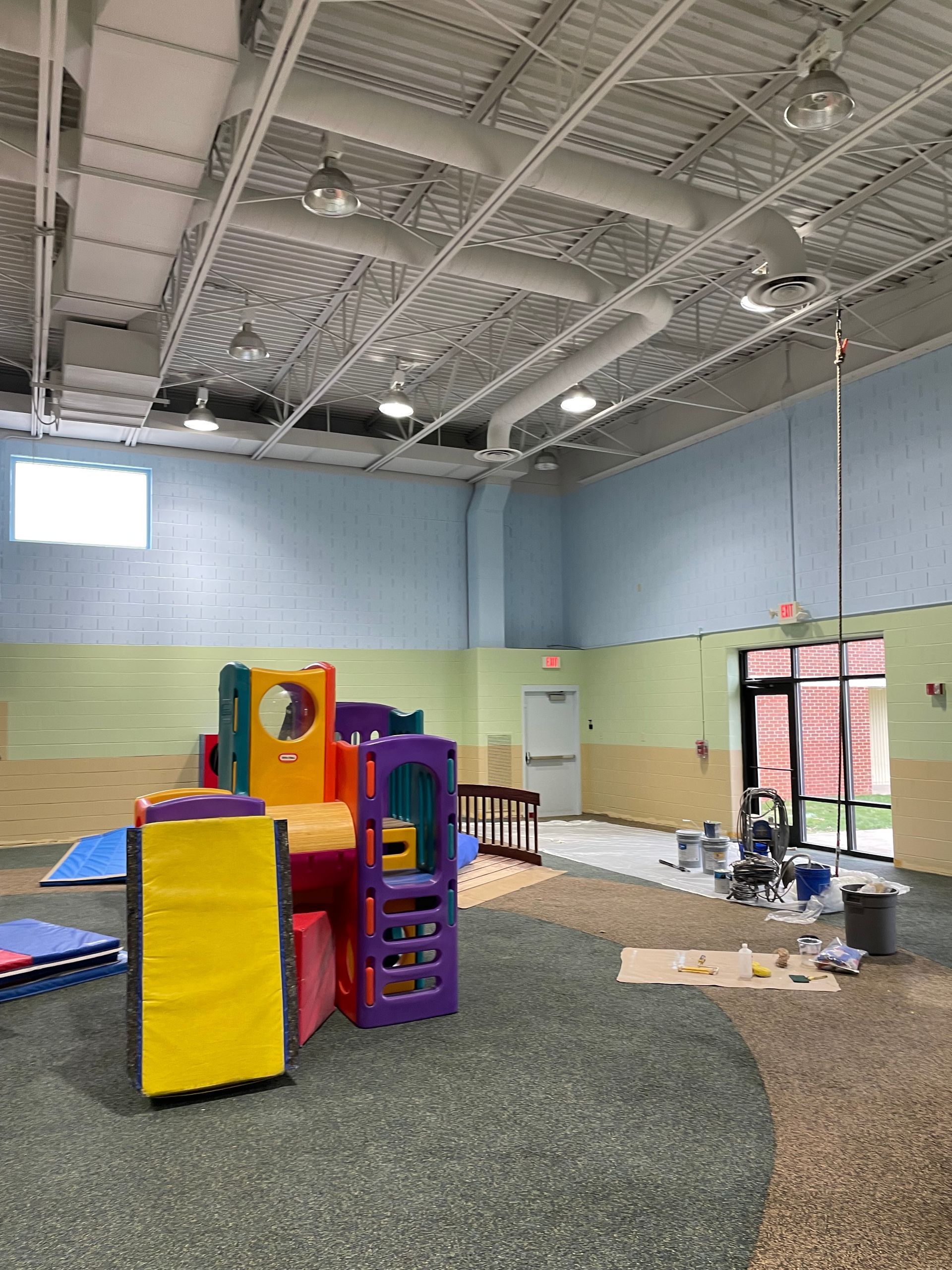 A large room with a playground in the middle of it.