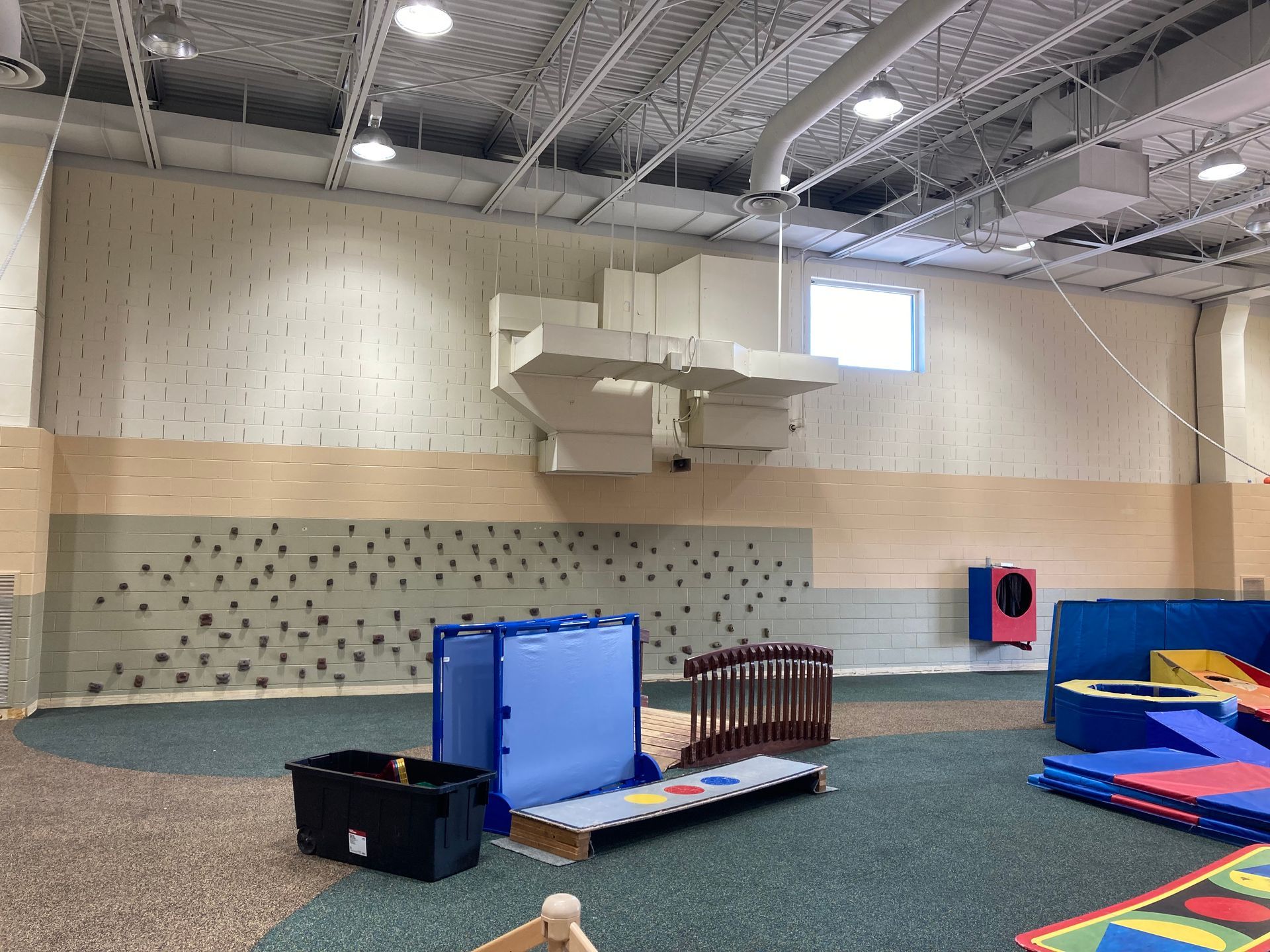 There is a climbing wall in the middle of the room.