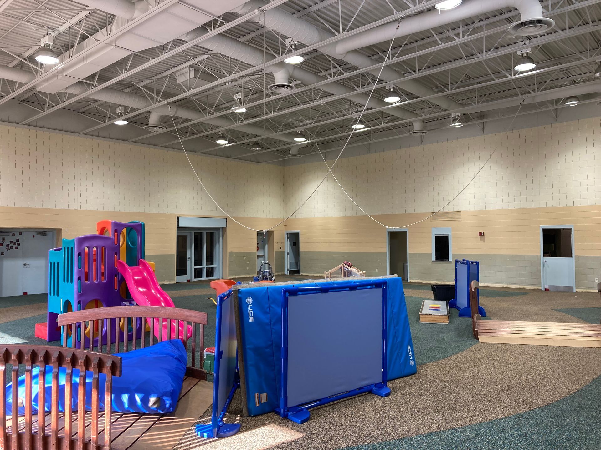A large indoor playground with a slide and a trampoline.