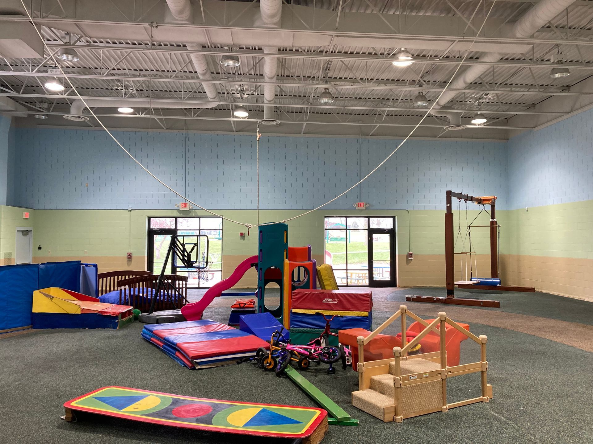 A large room filled with lots of colorful toys and a slide.