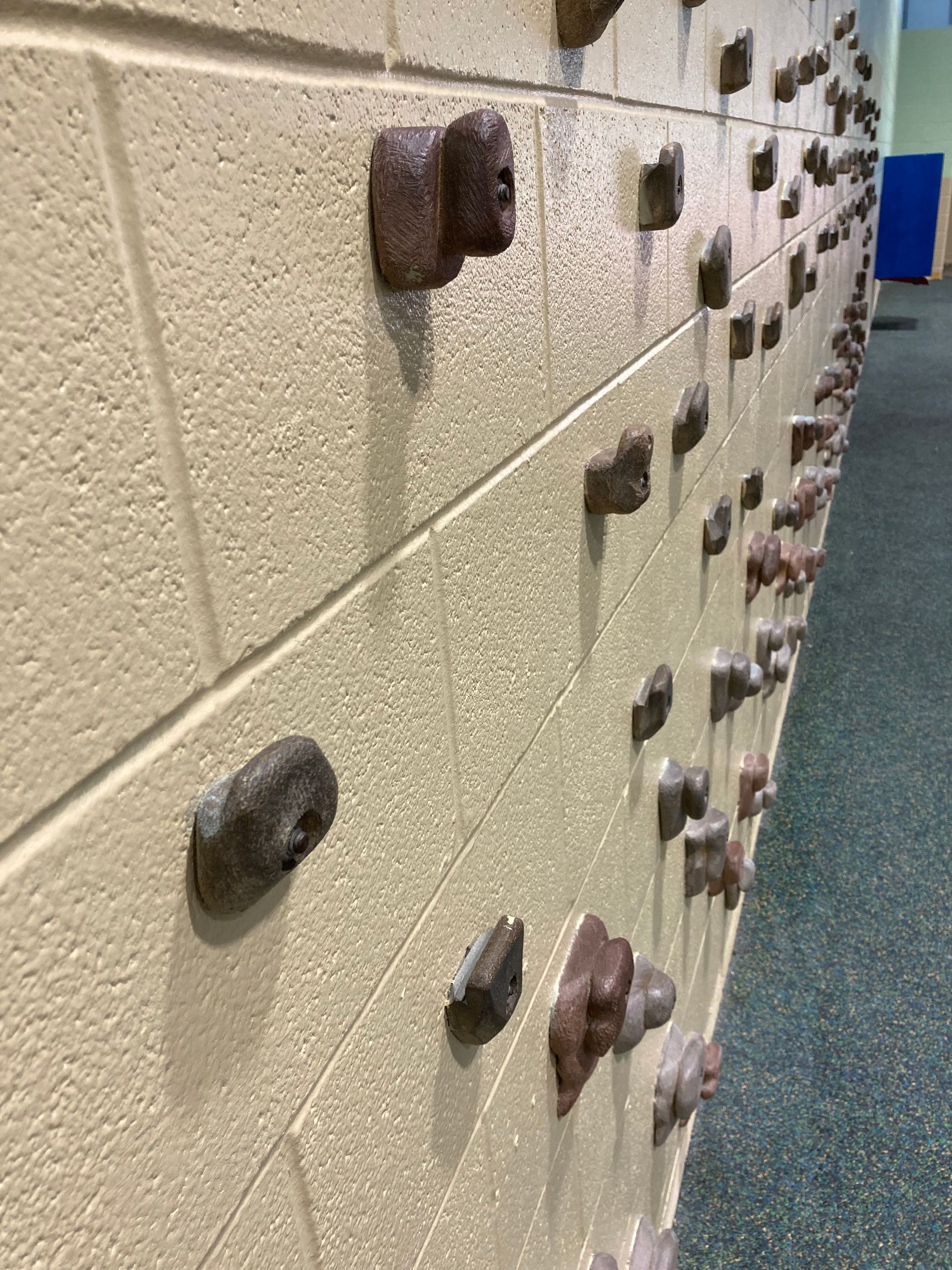 A row of lockers are lined up on a brick wall.