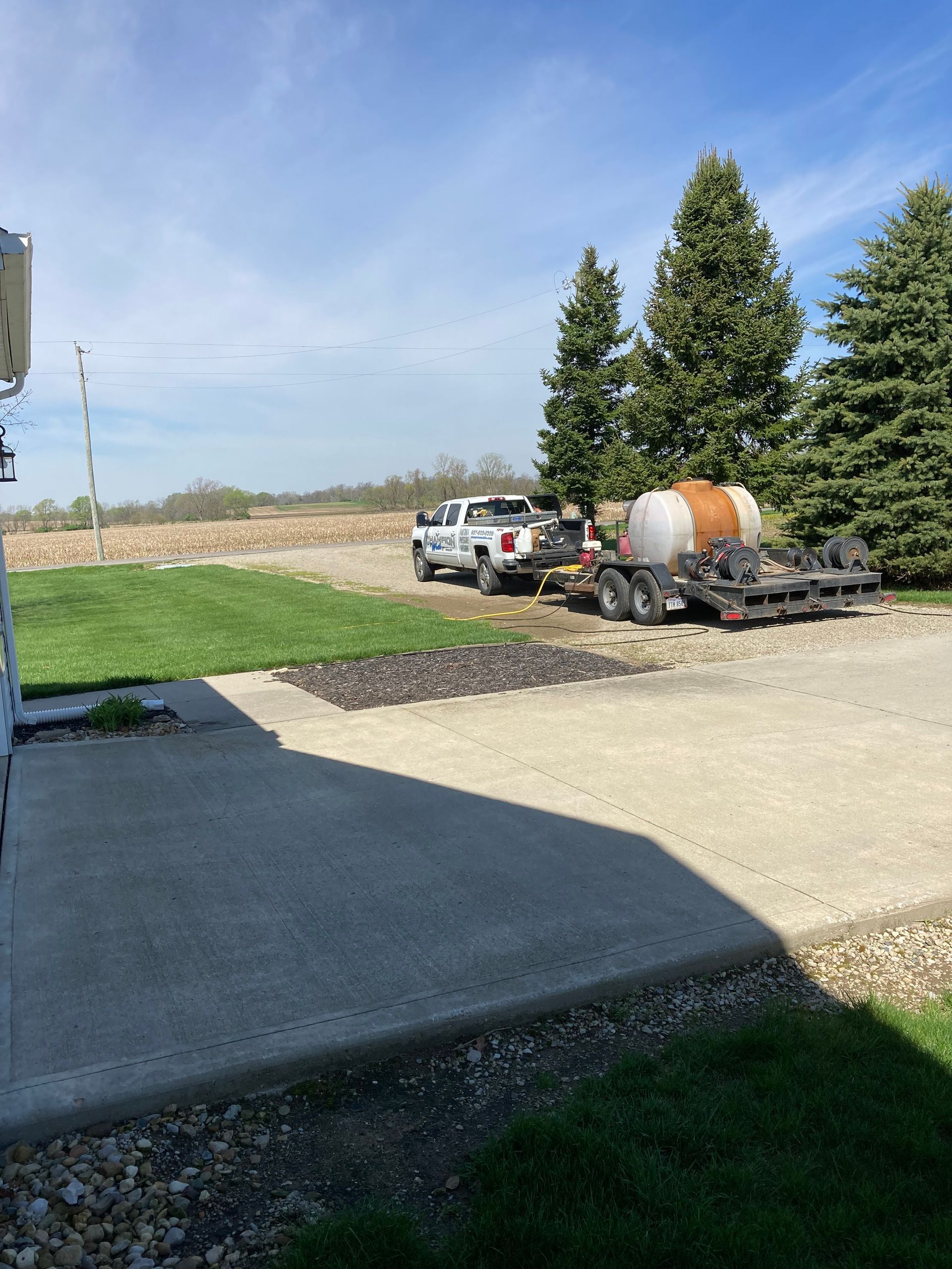 A truck with a trailer attached to it is parked in a driveway.
