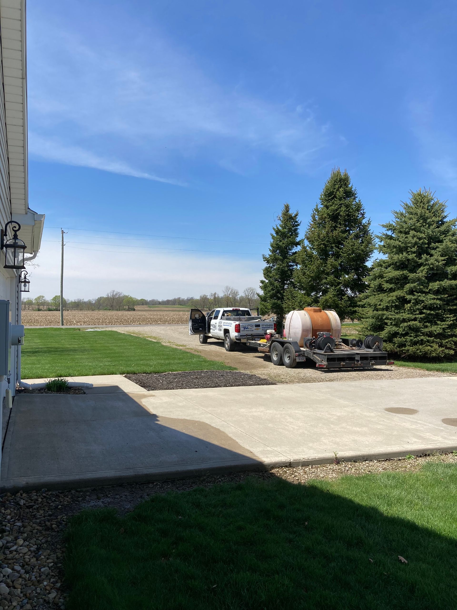 Two trucks are parked in a driveway next to a house.