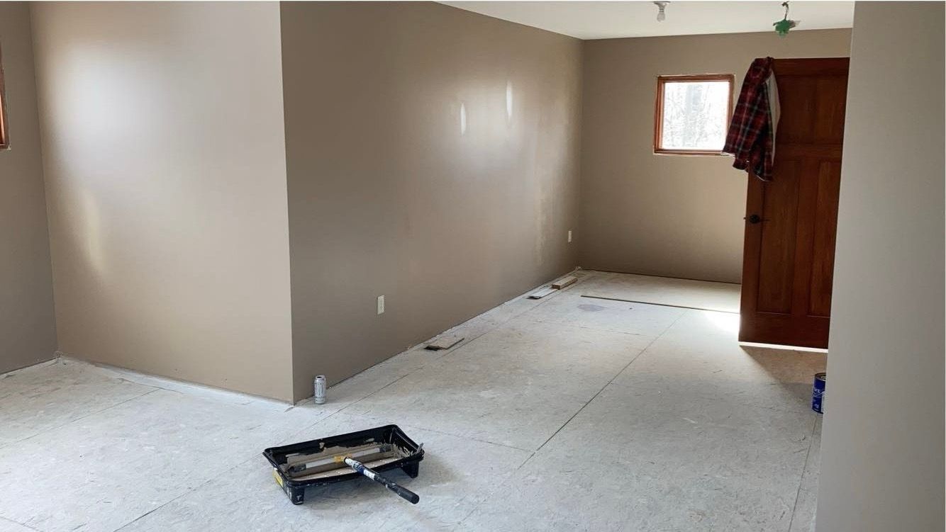 An empty room with a tray of tools on the floor.