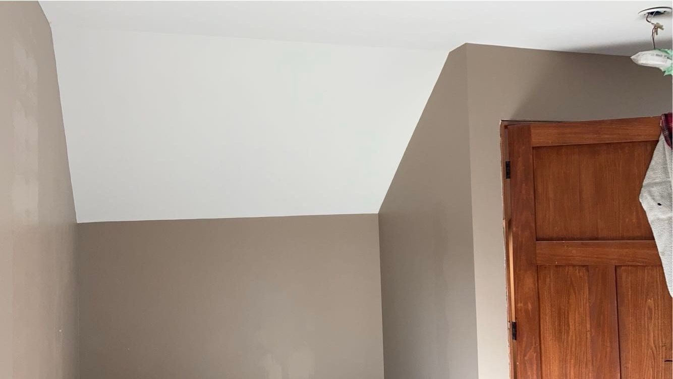 A room with a wooden door and a white ceiling.