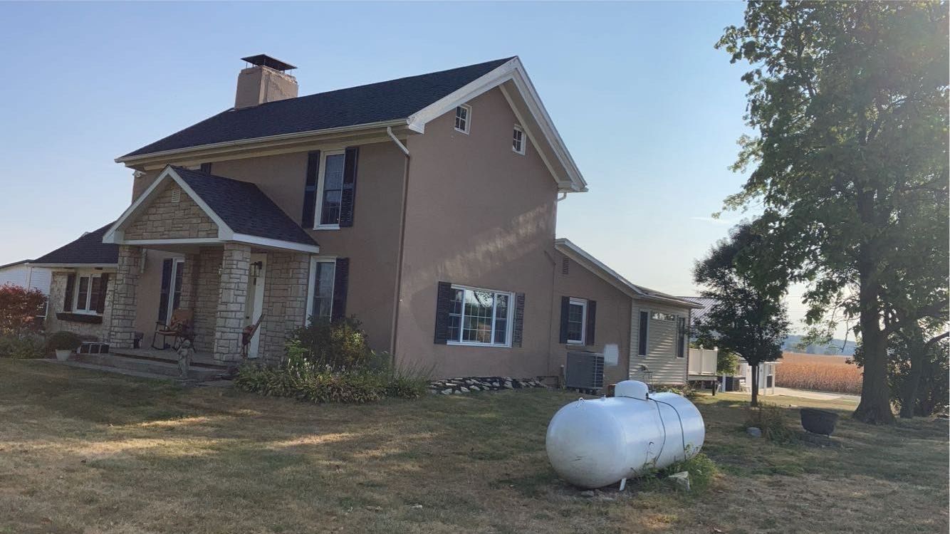 A large house with a propane tank in front of it