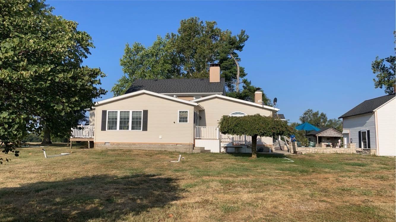 A house is sitting in the middle of a grassy field.