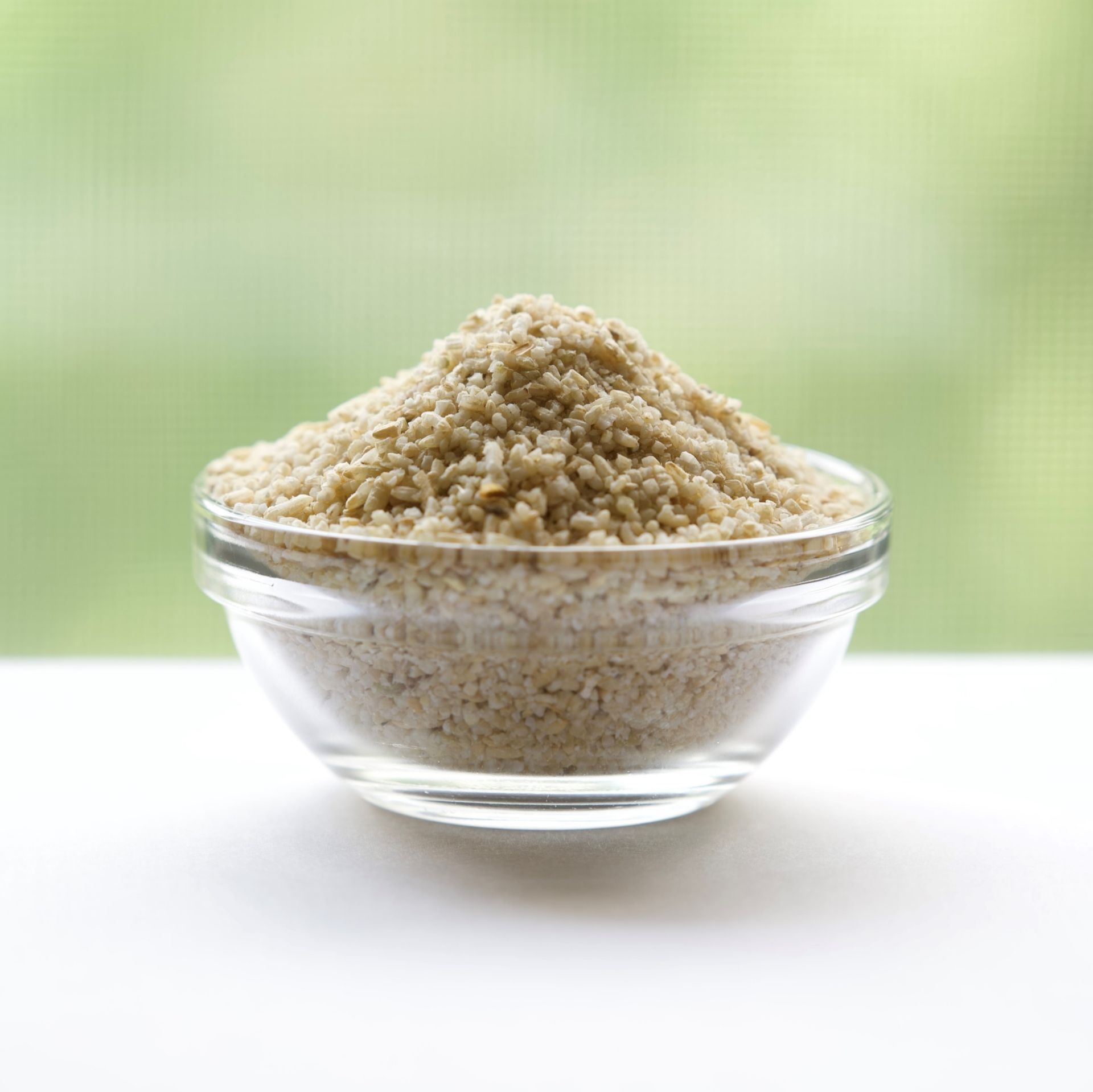 A glass bowl filled with rice is on a table.