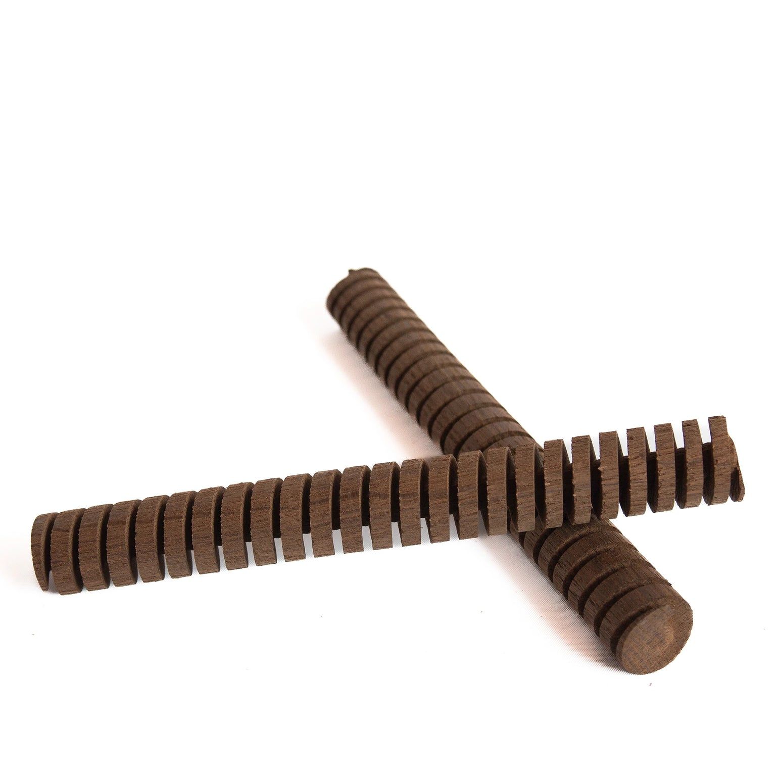 Two wooden sticks are crossed over each other on a white surface