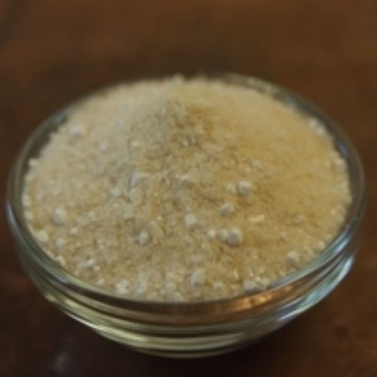 A glass bowl filled with white powder on a wooden table