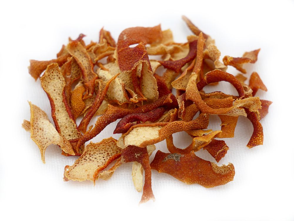 A pile of dried orange peel on a white surface.