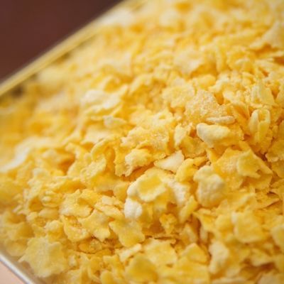 A close up of a pile of corn flakes on a tray.